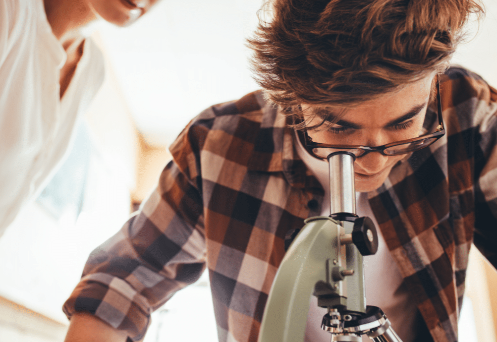 Homeschool student looking into a microscope.